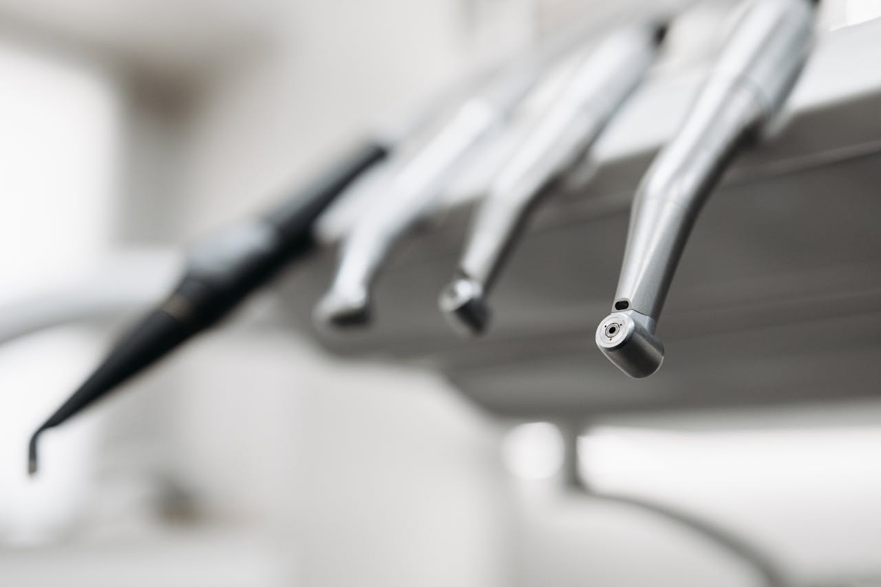 journey A detailed view of stainless steel dental tools in a modern dentist's office.